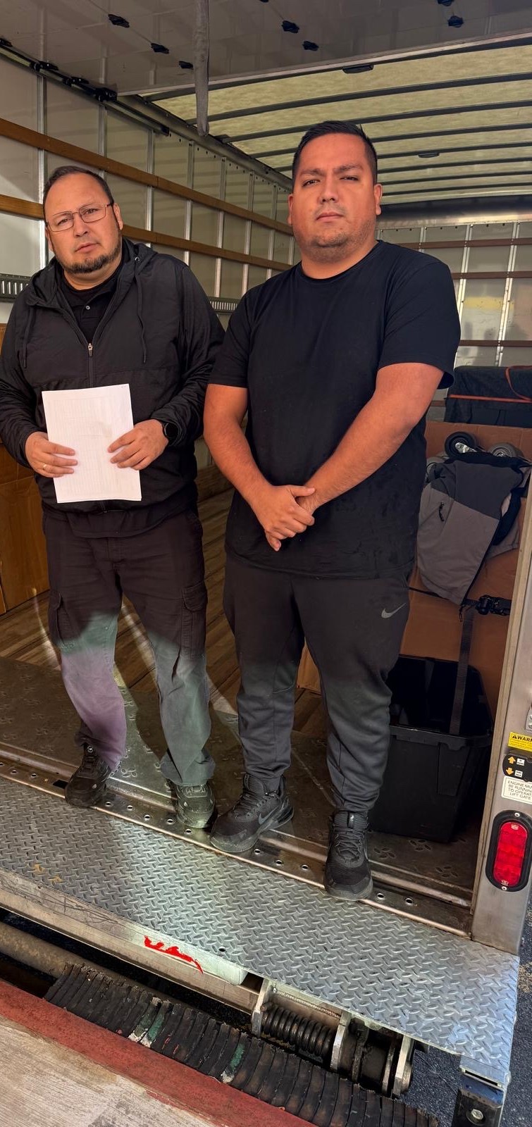 Professional movers from E-Logic moving standing inside a truck